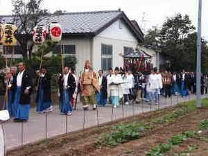 神輿と人々がみえる渡御行列のようすの写真