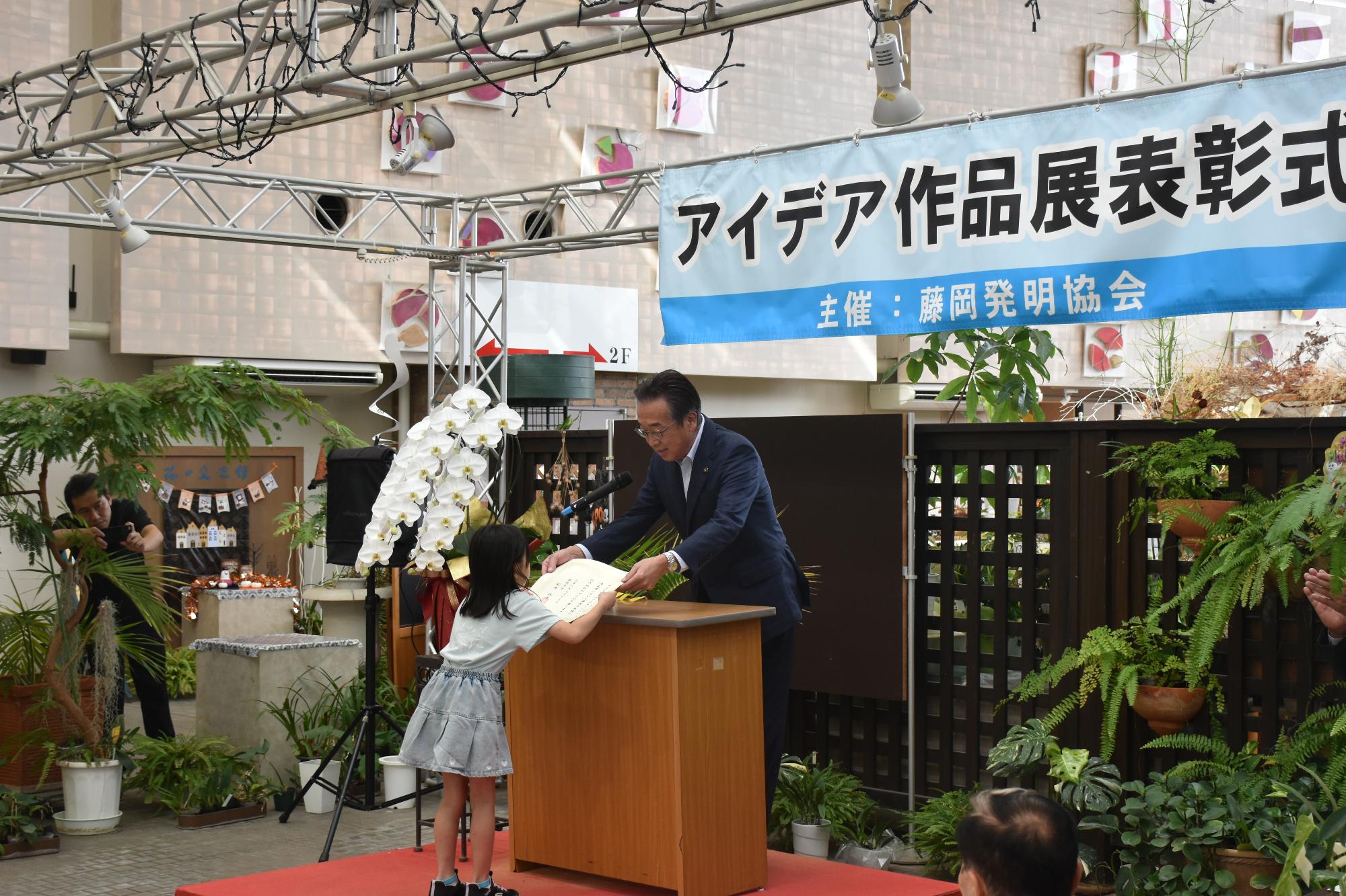 R08発明協会アイデア作品展で症状を授与する新井市長