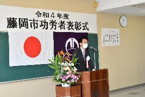 式典で受章者へあいさつをする新井藤岡市長
