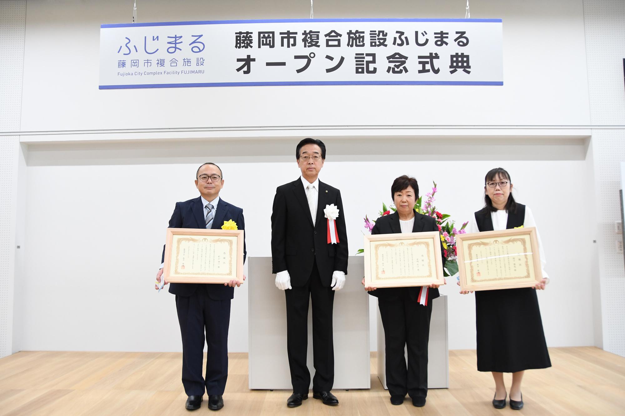 R07ふじまるの名称を考案した3名の方に表彰状を送る新井市長