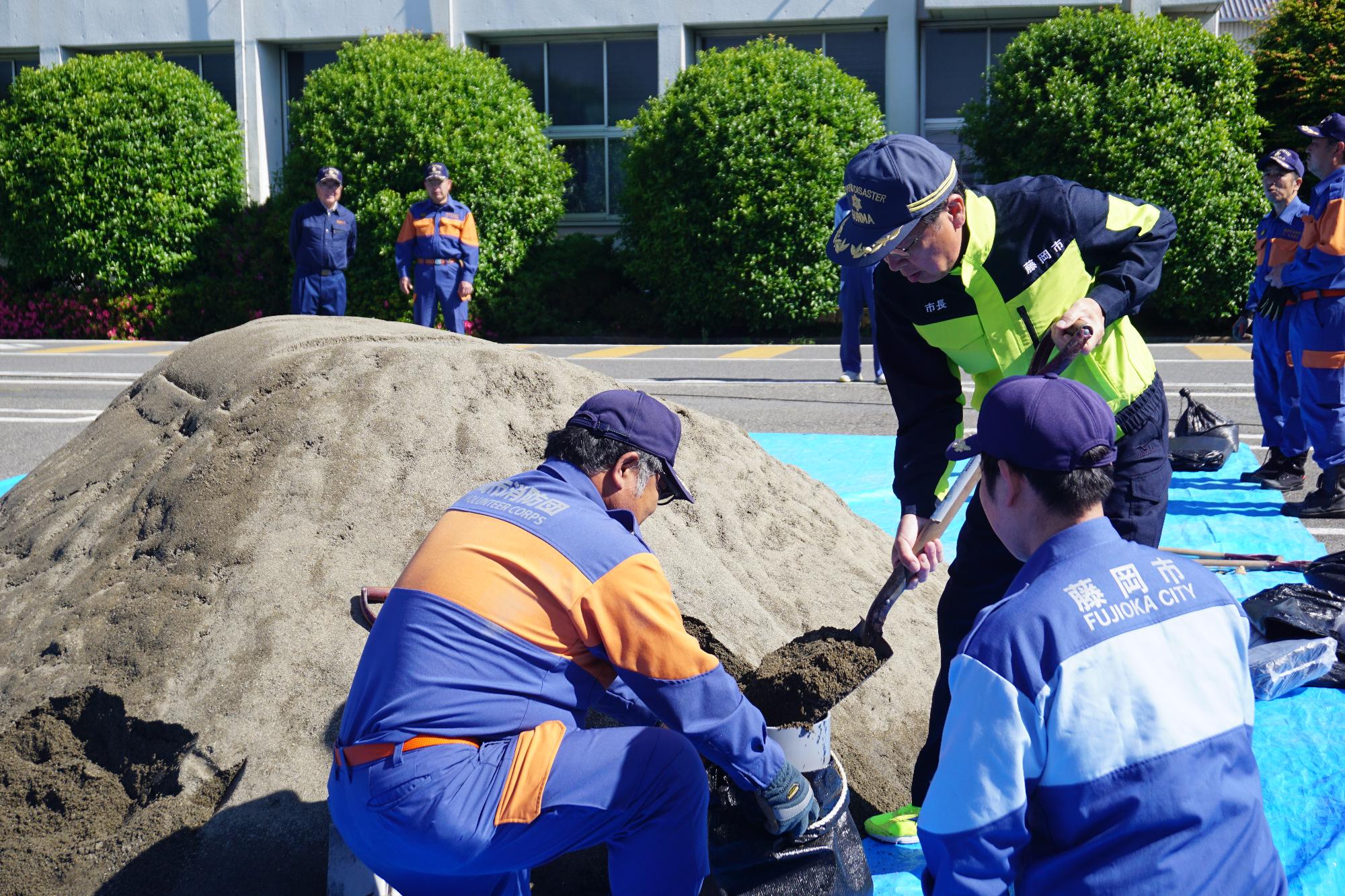 R08消防団水防工法実技訓練で土嚢を作成する新井市長