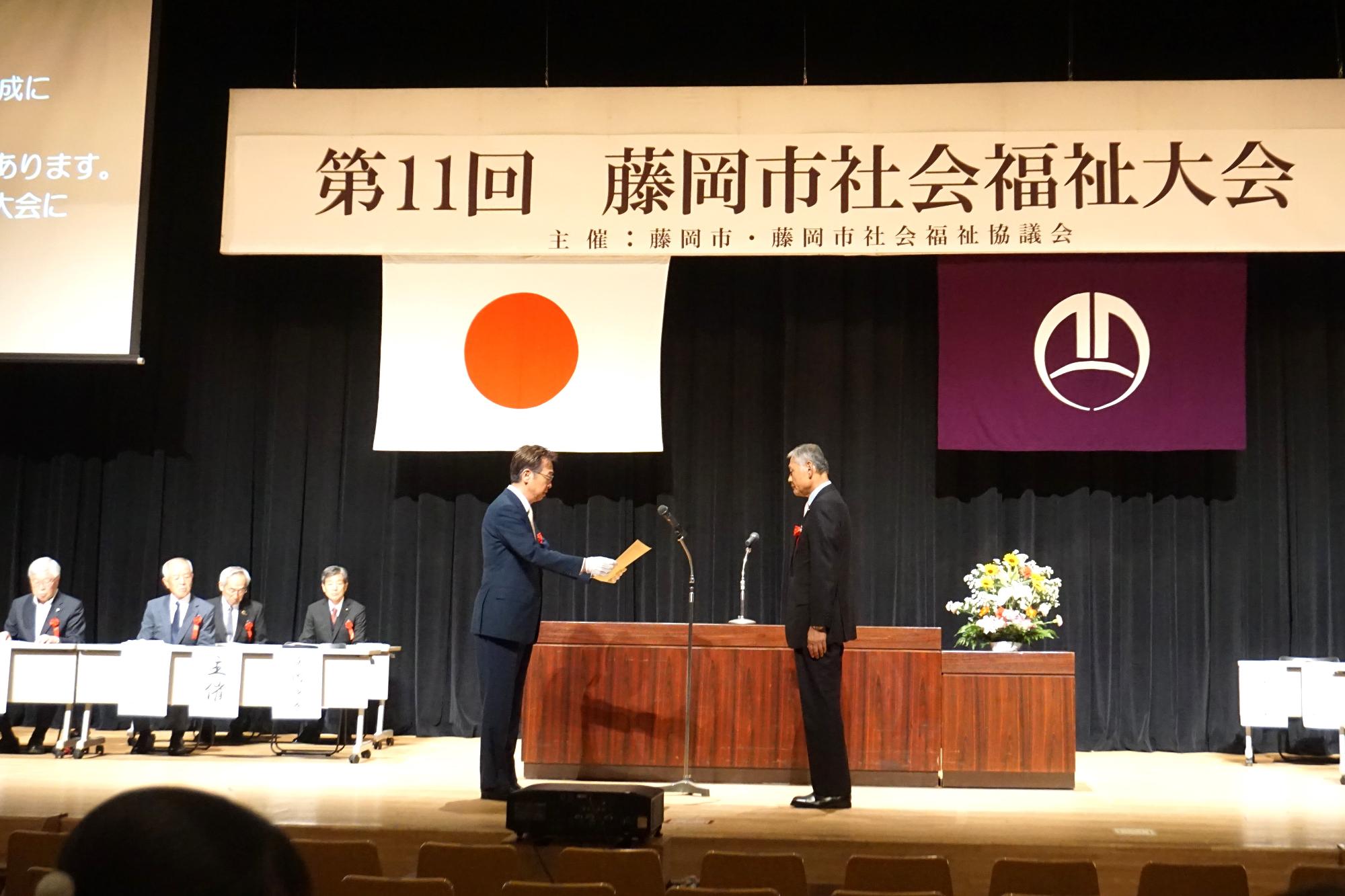 R08社会福祉大会で表彰状を授与するあ新井市長