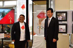 展示したトーチの前に立つ市長と内藤聡さん