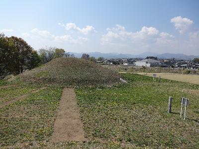 青空と北側からみた毛野国白石丘陵公園のなかの皇子塚古墳の写真