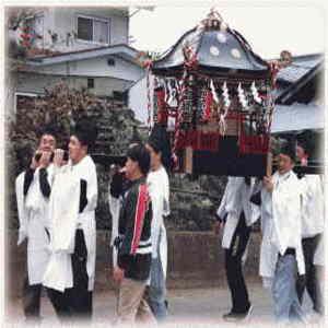 三嶋神社の夜祭の神輿を担ぐ白装束の人々の写真