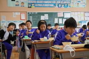 給食を食べる児童の画像