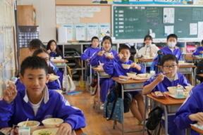 給食を食べる児童の画像